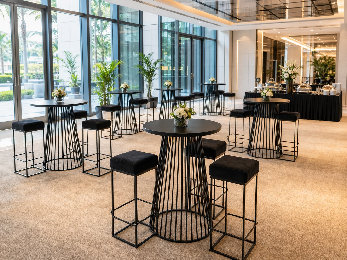 Black wire high bar tables with matching padded stools in a bright foyer reception setup