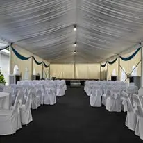 Marquee with white chair covers and round table layout